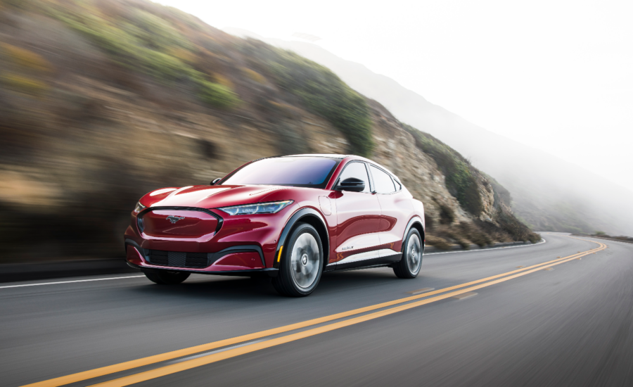 A red Ford Mustang Mach-E SUV on a highway