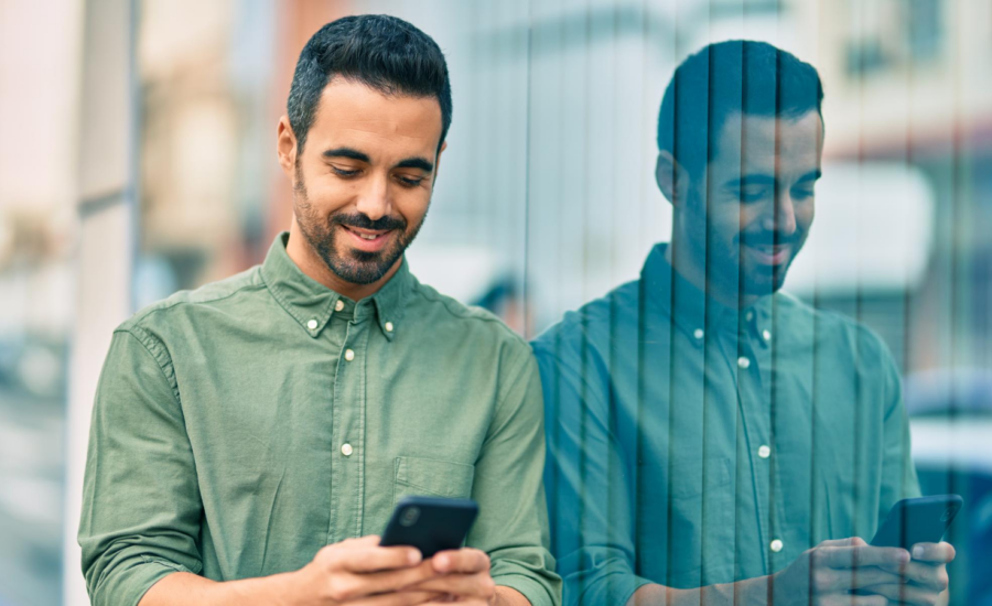A man smiles as he checks his phone